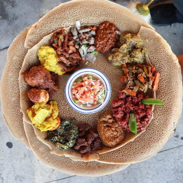 Rosalind's Ethiopian platter with various stews, vegetables, and injera bread, viewed from above.