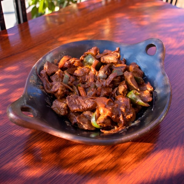Rosalind's Ethiopian Tibs, a dish of spiced meat and vegetables, served in a dark clay bowl.